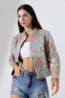 Model in a short satin embroidered jacket golden oranges and reds  reversible to silver side